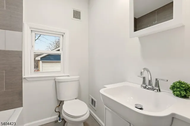 a bathroom with a toilet a sink and mirror