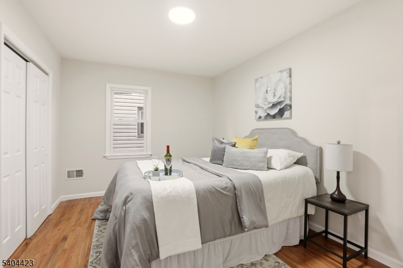 112 University Place Irvington, NJ 07111 - Photo 25 of 31 a bedroom with a bed and wooden floor