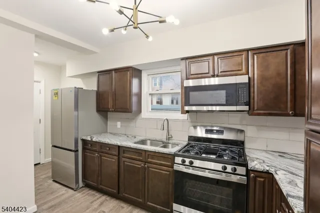 a kitchen with stainless steel appliances granite countertop a stove microwave and refrigerator