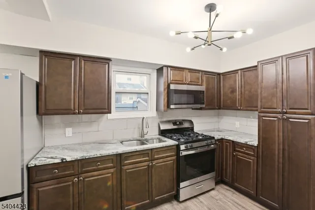 a kitchen with stainless steel appliances granite countertop a stove refrigerator and microwave