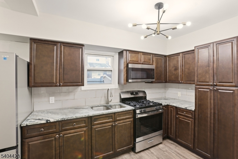 112 University Place Irvington, NJ 07111 - Photo 28 of 31 a kitchen with stainless steel appliances granite countertop a stove refrigerator and microwave