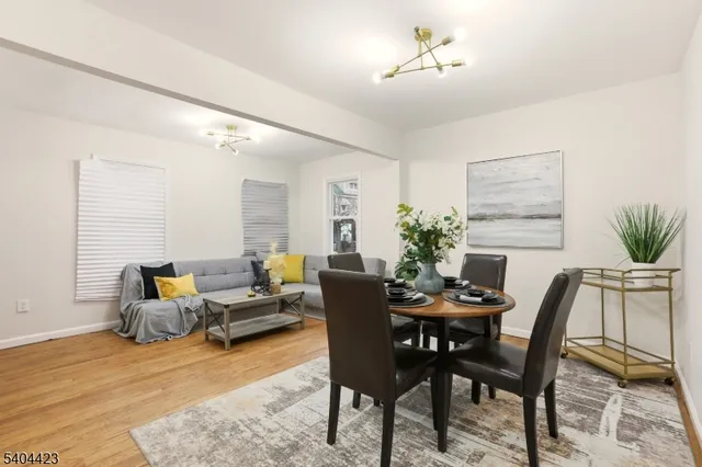 a dining room with furniture potted plants and wooden floor