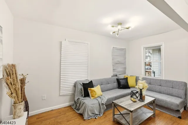 a living room with furniture a wooden floor and a chandelier