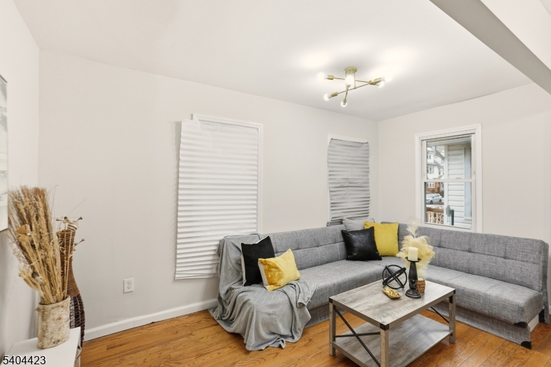 112 University Place Irvington, NJ 07111 - Photo 6 of 31 a living room with furniture a wooden floor and a chandelier