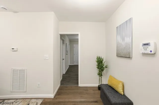 a hallway with wooden floor and mirror