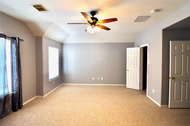 a view of an empty room with a ceiling fan