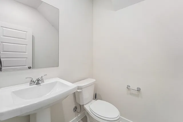 a bathroom with a sink mirror and toilet
