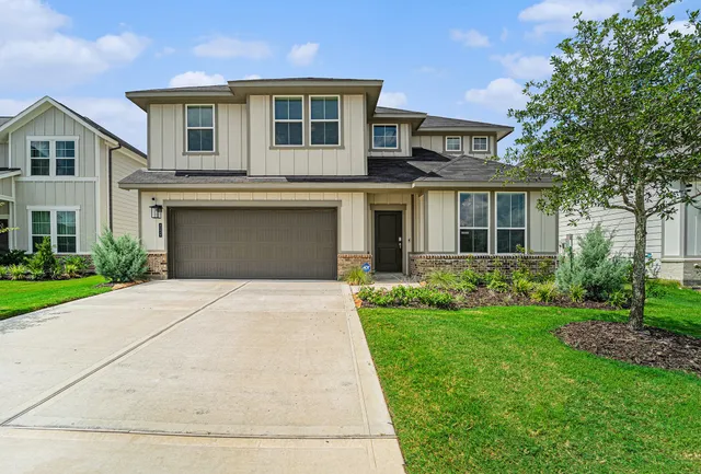a front view of a house with a garden and yard