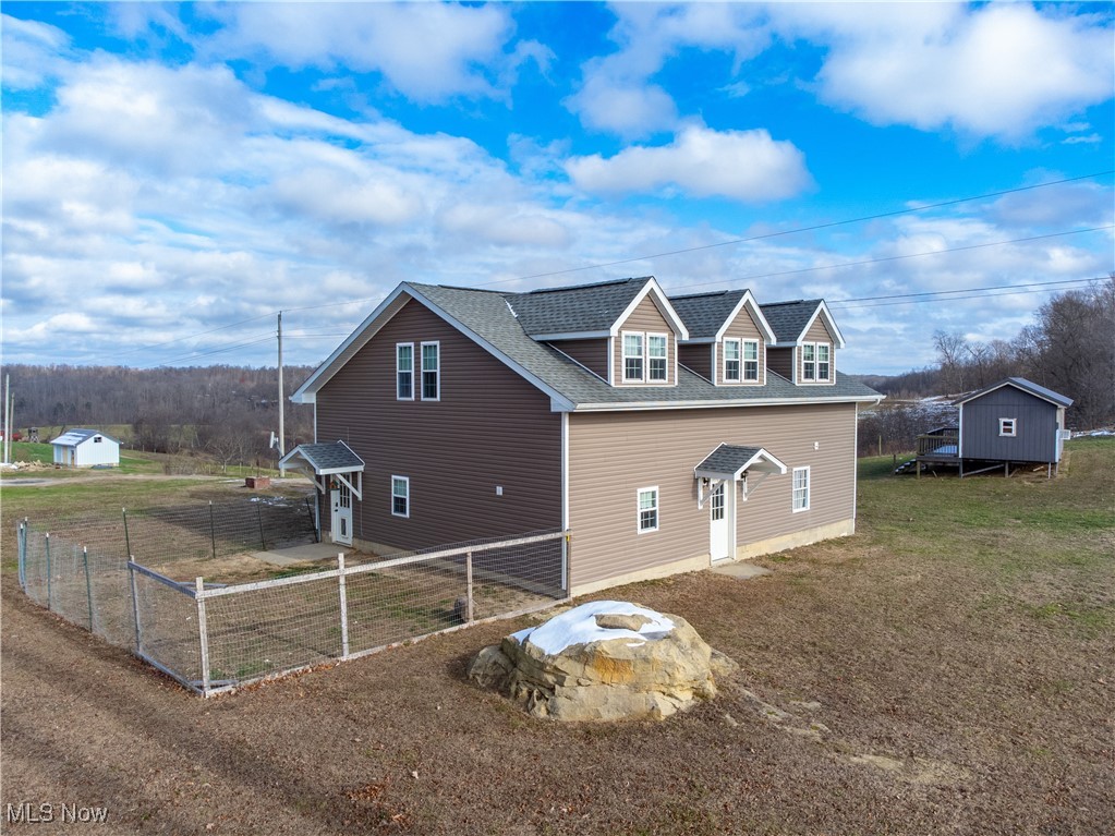 57459 Shry Road Barnesville, OH 43713 - Photo 32 of 44 View of side of property featuring an outdoor fire pit, a storage shed, and a shingled roof