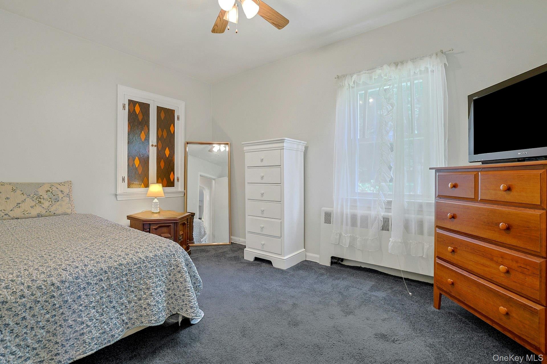 31 Townline Road Pearl River, NY 10965 - Photo 16 of 27 a bedroom with a bed and a flat tv screen on dresser