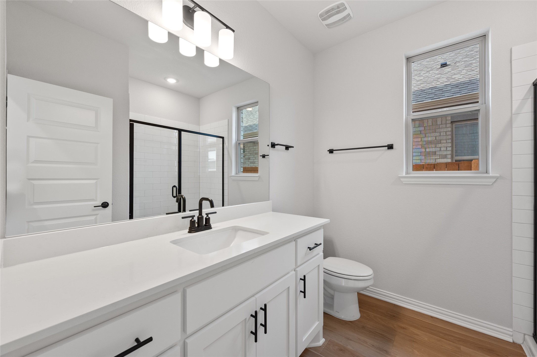 303 Fawn Riv Run Kyle, TX 78640 - Photo 25 of 32 Bathroom vanity featuring a single basin sink, white countertop, and dark-finish faucet