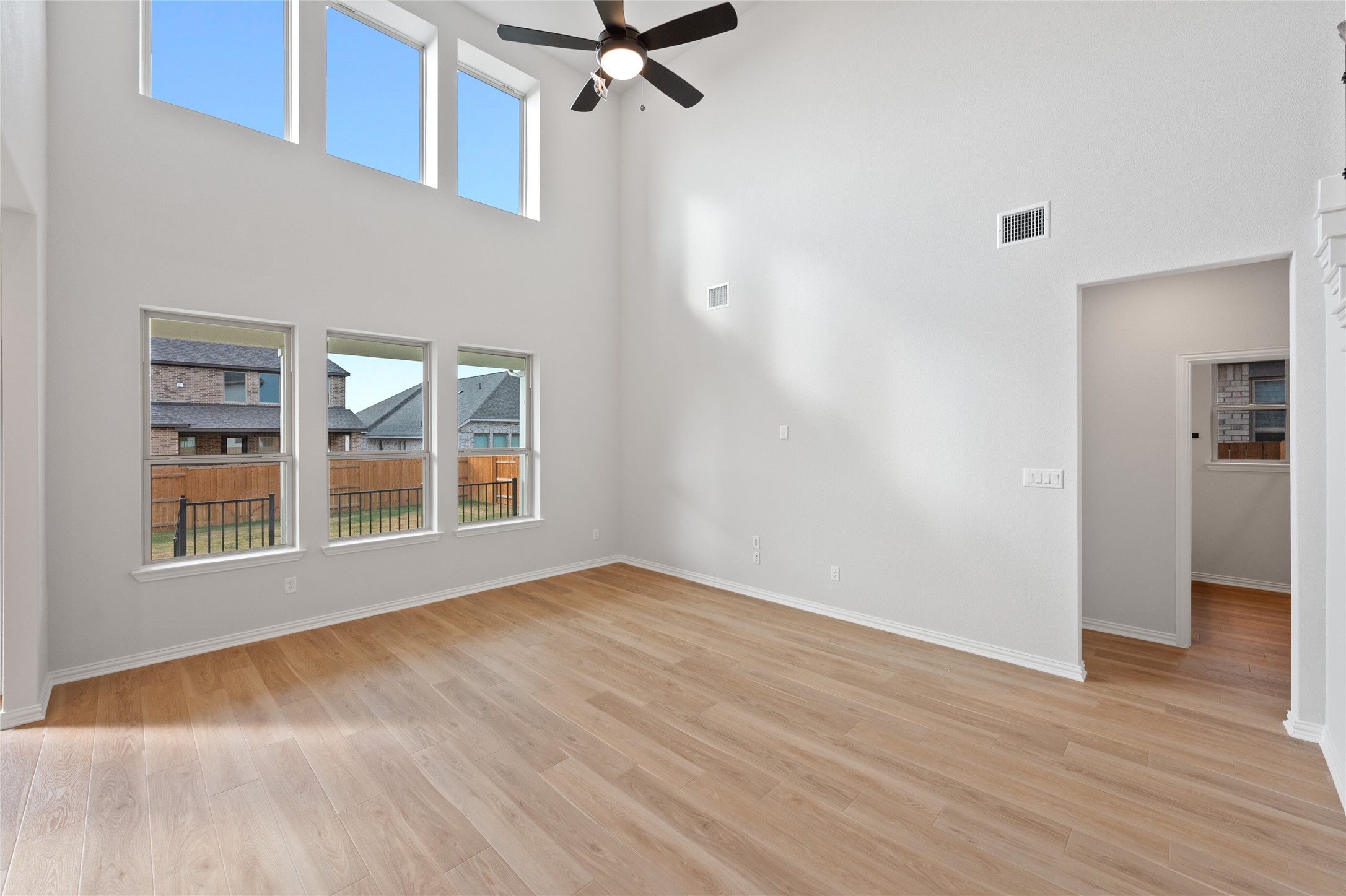303 Fawn Riv Run Kyle, TX 78640 - Photo 3 of 32 Expansive living space featuring a soaring ceiling, wood-finish flooring, and multiple windows