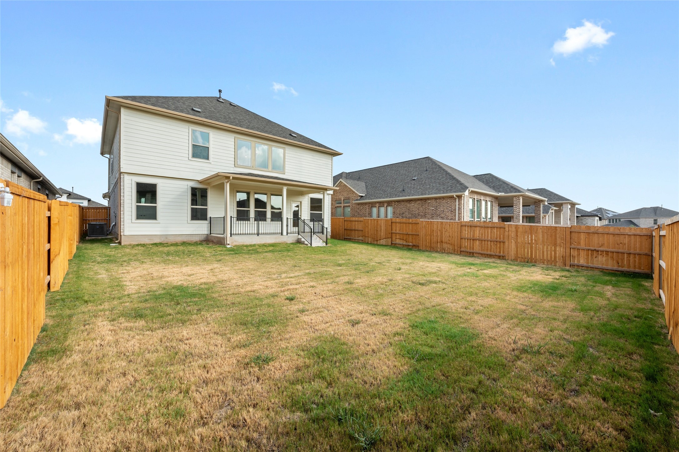 303 Fawn Riv Run Kyle, TX 78640 - Photo 31 of 32 Spacious backyard featuring a covered patio, multiple windows, and a full wood privacy fence