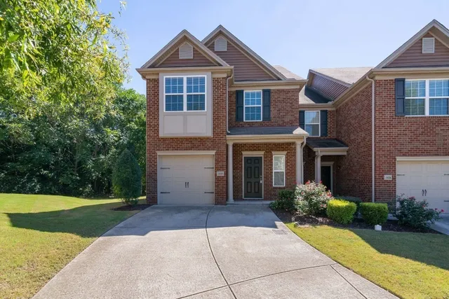 a front view of a house with yard and trees