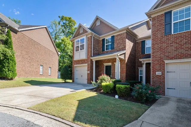 a front view of a house with a yard and potted plants