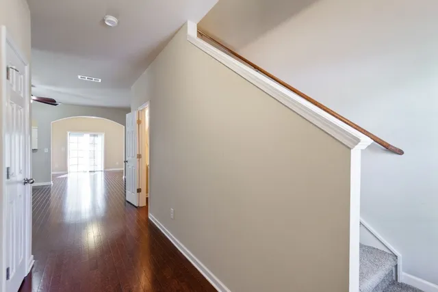 a view of a hallway with wooden floor and staircase