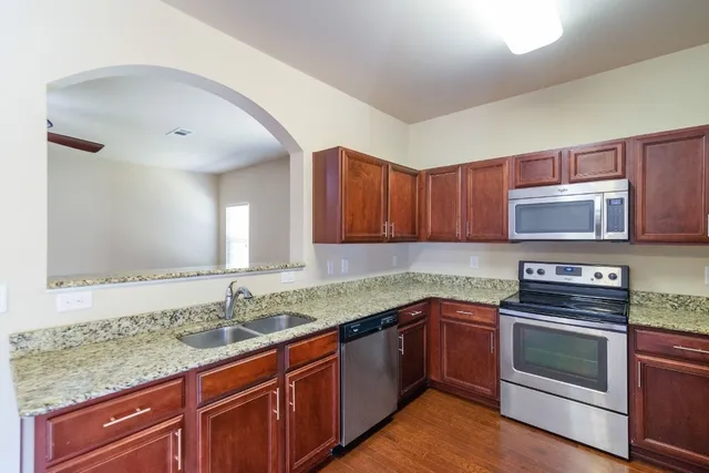 a kitchen with stainless steel appliances granite countertop a sink stove and microwave
