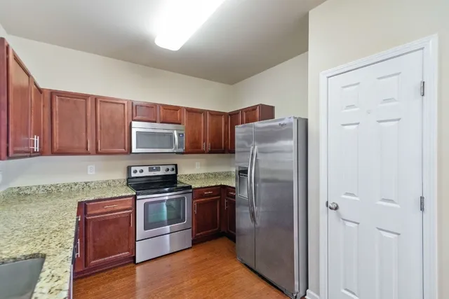 a kitchen with stainless steel appliances granite countertop a refrigerator stove and sink