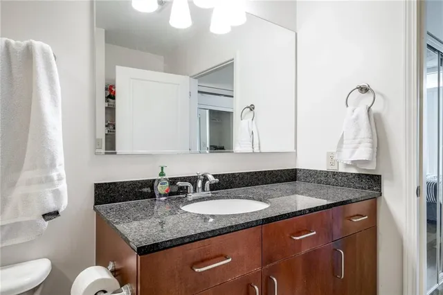 a bathroom with a granite countertop sink and a mirror