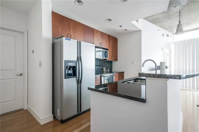 a kitchen with stainless steel appliances granite countertop a refrigerator stove and a sink
