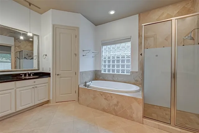 a large white bathroom with a large tub a sink and shower