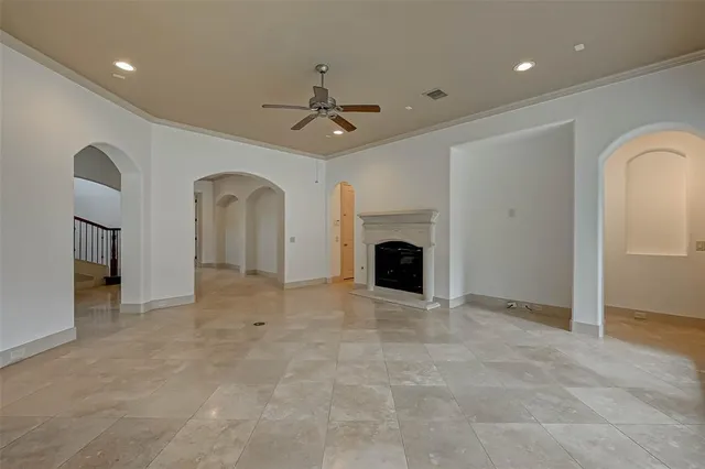 a view of empty room with fireplace and fan