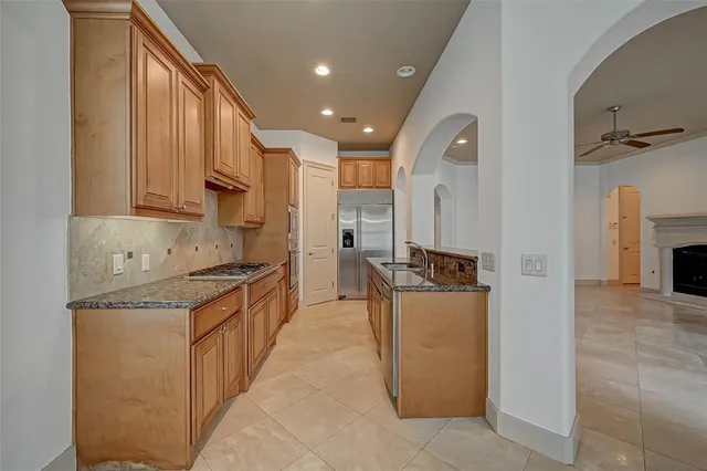 a large kitchen with stainless steel appliances granite countertop a stove and a refrigerator