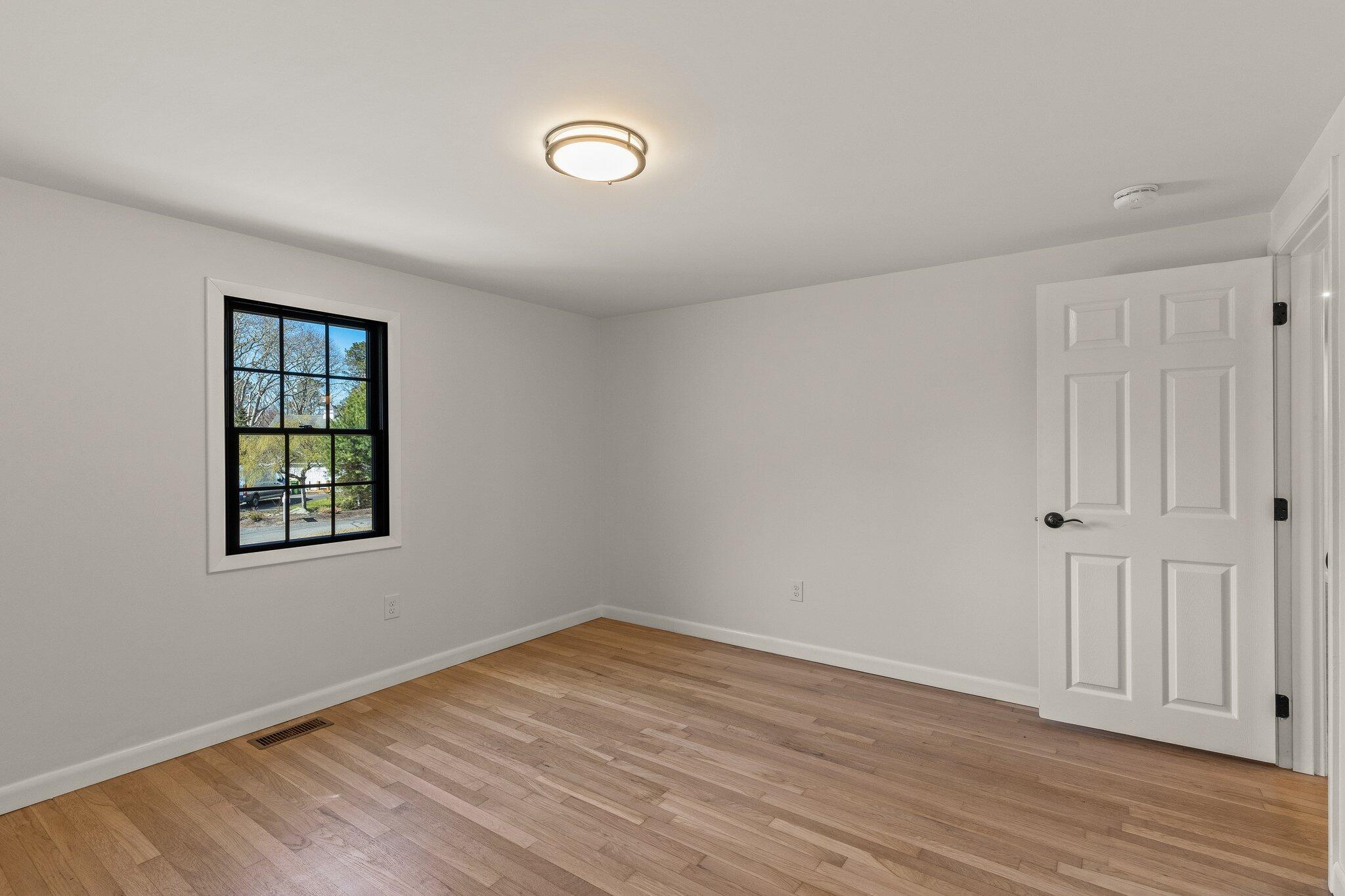 101 Monomoyic Way Chatham, MA 02633 - Photo 21 of 59 a view of an empty room with wooden floor and a window