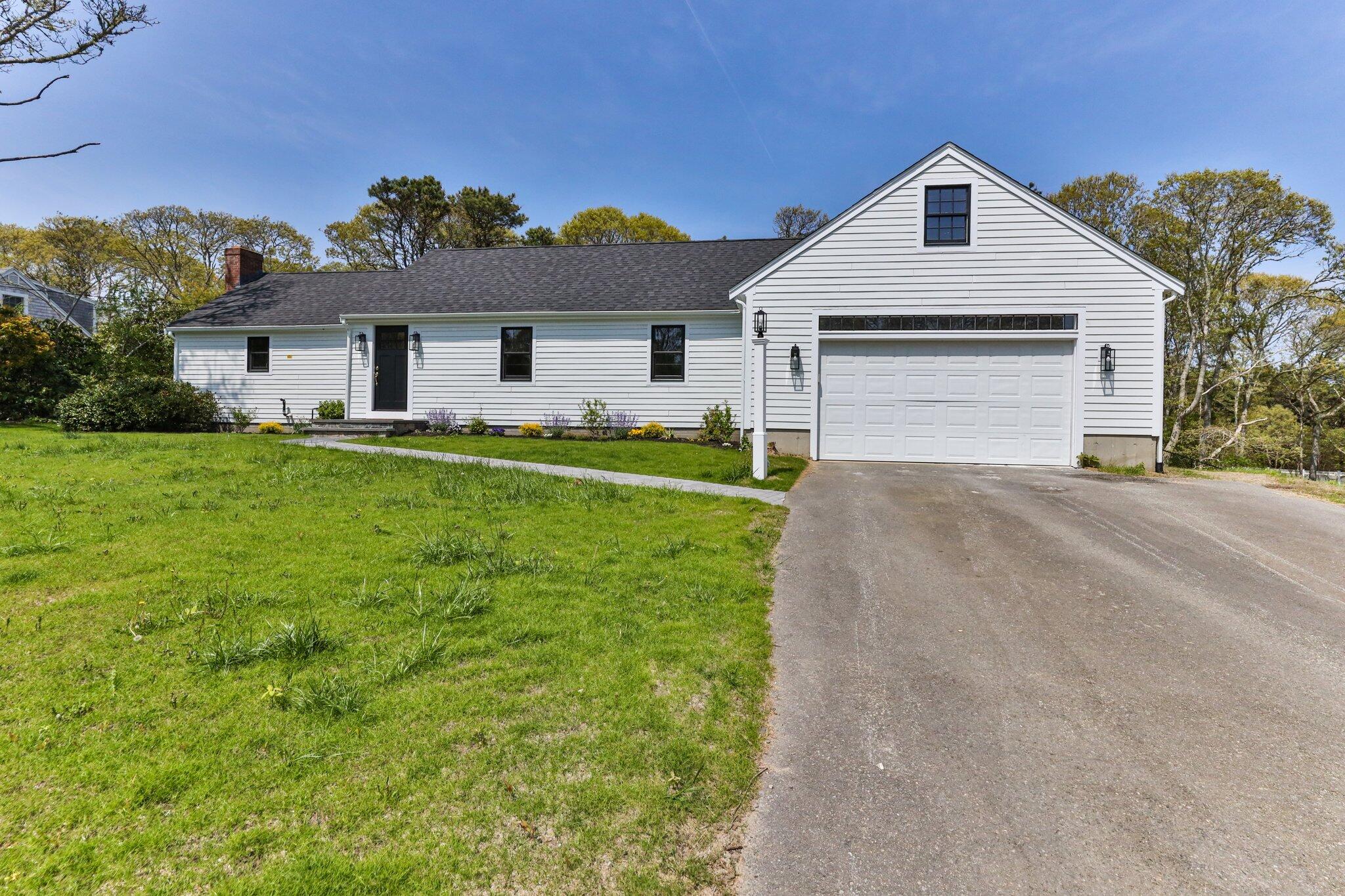 101 Monomoyic Way Chatham, MA 02633 - Photo 55 of 59 a front view of a house with a yard and garage