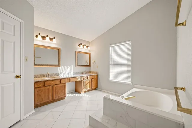 an empty room with wooden floor chandelier fan and windows