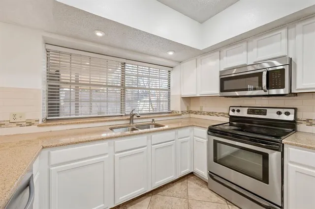 a large white kitchen with a large window