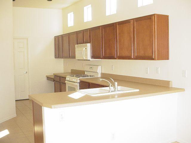 360 Del Lupo Court Rio Rico, AZ 85648 - Photo 4 of 7 a kitchen with a sink a stove and a microwave