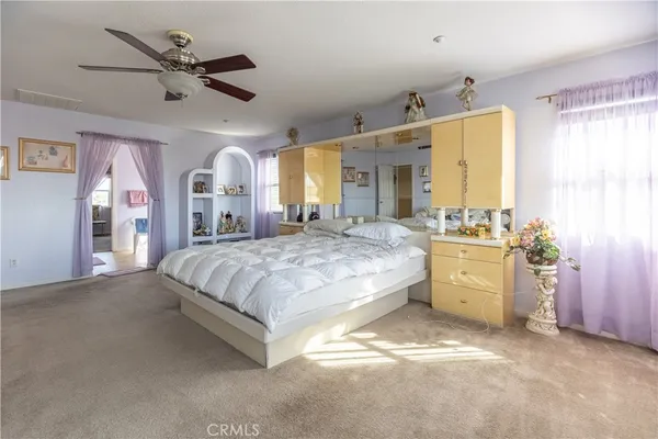 a spacious bedroom with a large bed and a chandelier