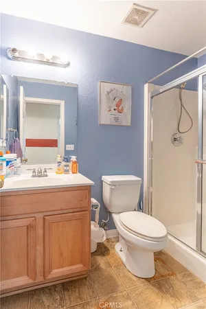 a bathroom with a granite countertop toilet sink and mirror