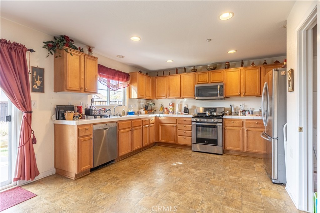 9131 Santa Barbara Drive Riverside, CA 92508 - Photo 2 of 29 a kitchen with a refrigerator sink cabinets and wooden floor