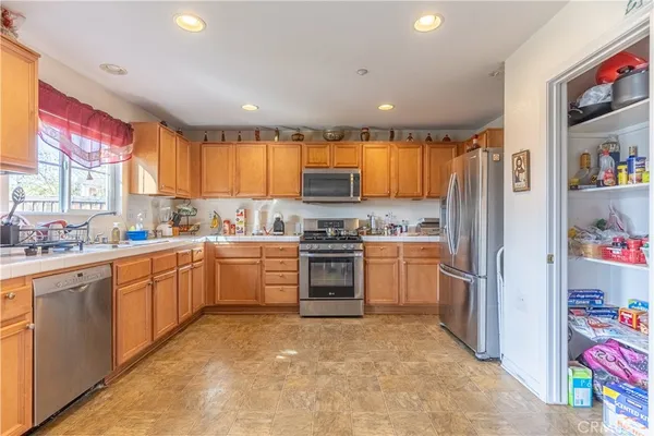 a kitchen with a refrigerator sink and cabinets