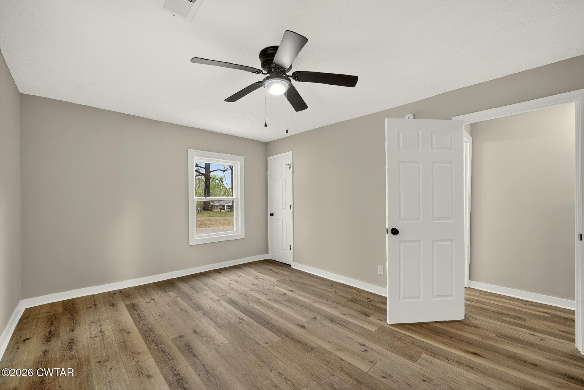 402 Harts Bridge Road Jackson, TN 38301 - Photo 13 of 38 a view of an empty room with wooden floor and a window