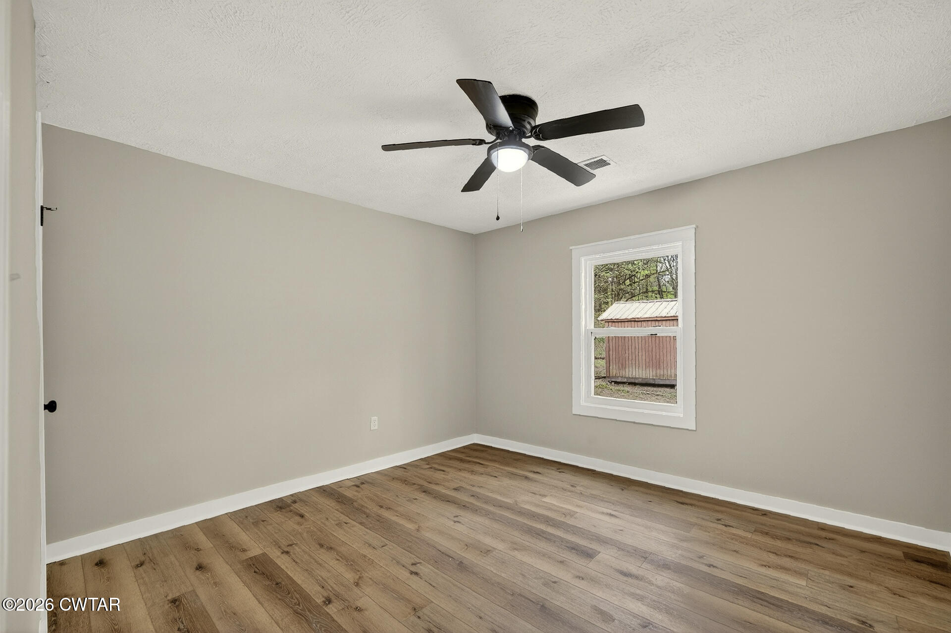 402 Harts Bridge Road Jackson, TN 38301 - Photo 18 of 38 a view of empty room with wooden floor and fan