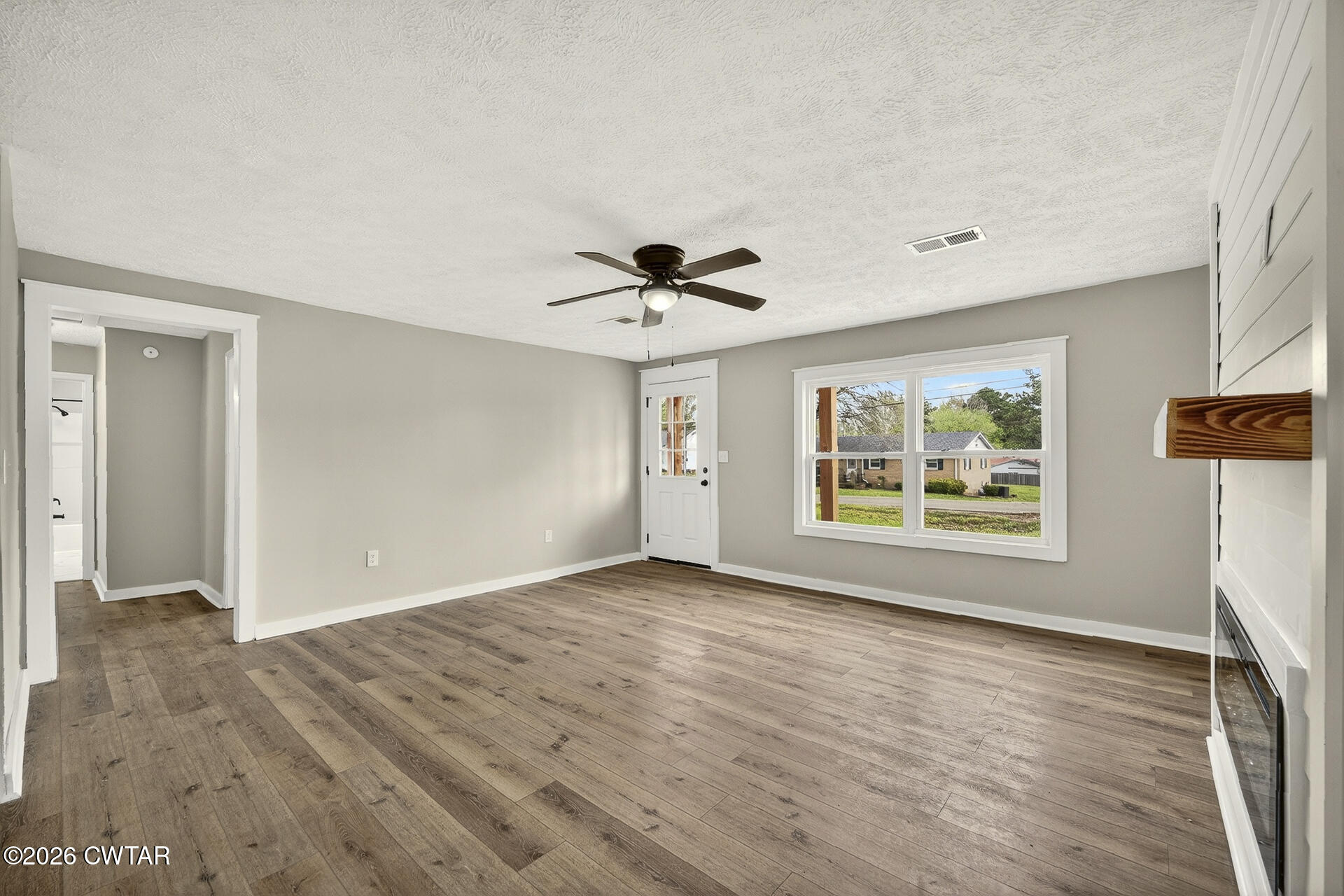 402 Harts Bridge Road Jackson, TN 38301 - Photo 5 of 38 a view of an empty room with a window and wooden floor