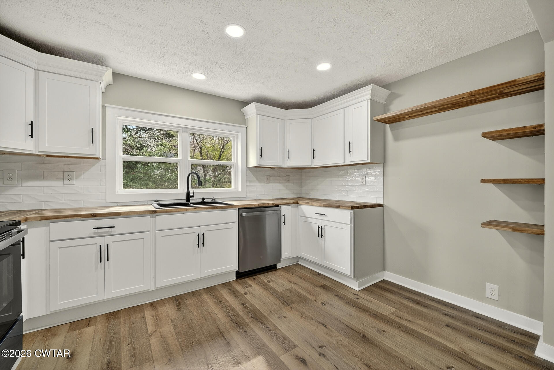 402 Harts Bridge Road Jackson, TN 38301 - Photo 8 of 38 a kitchen with granite countertop white cabinets and white appliances