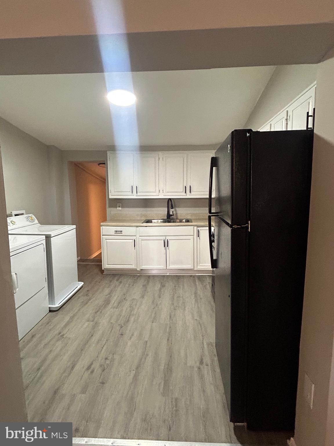 1807 Ramsay Street Baltimore, MD 21223 - Photo 4 of 13 a kitchen with a refrigerator and white cabinets