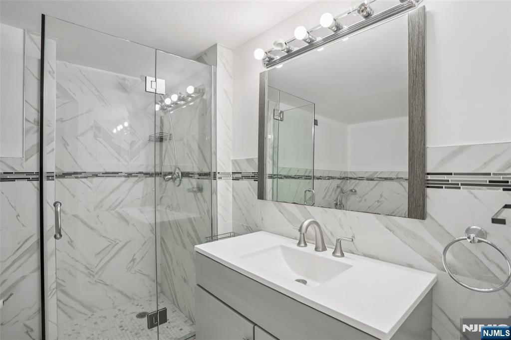 1077 River Road, Unit TH5 Edgewater, NJ 07020 - Photo 13 of 21 a bathroom with a sink a mirror and a shower