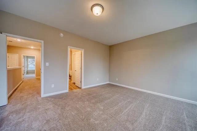 an empty room with windows and entrance to other room