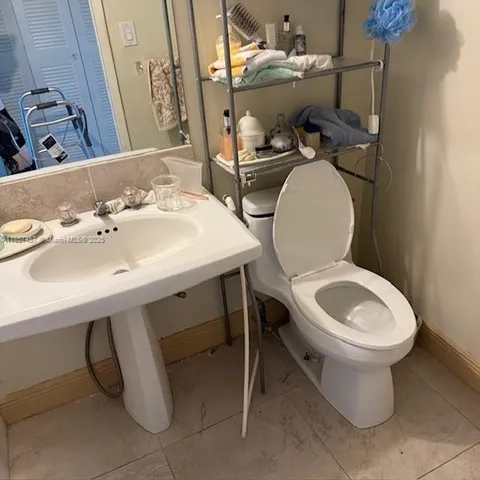 a bathroom with a sink mirror and toilet