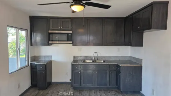 a kitchen with stainless steel appliances granite countertop wooden cabinets a stove top oven a sink and dishwasher