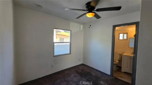 an empty room with a window and wooden floor