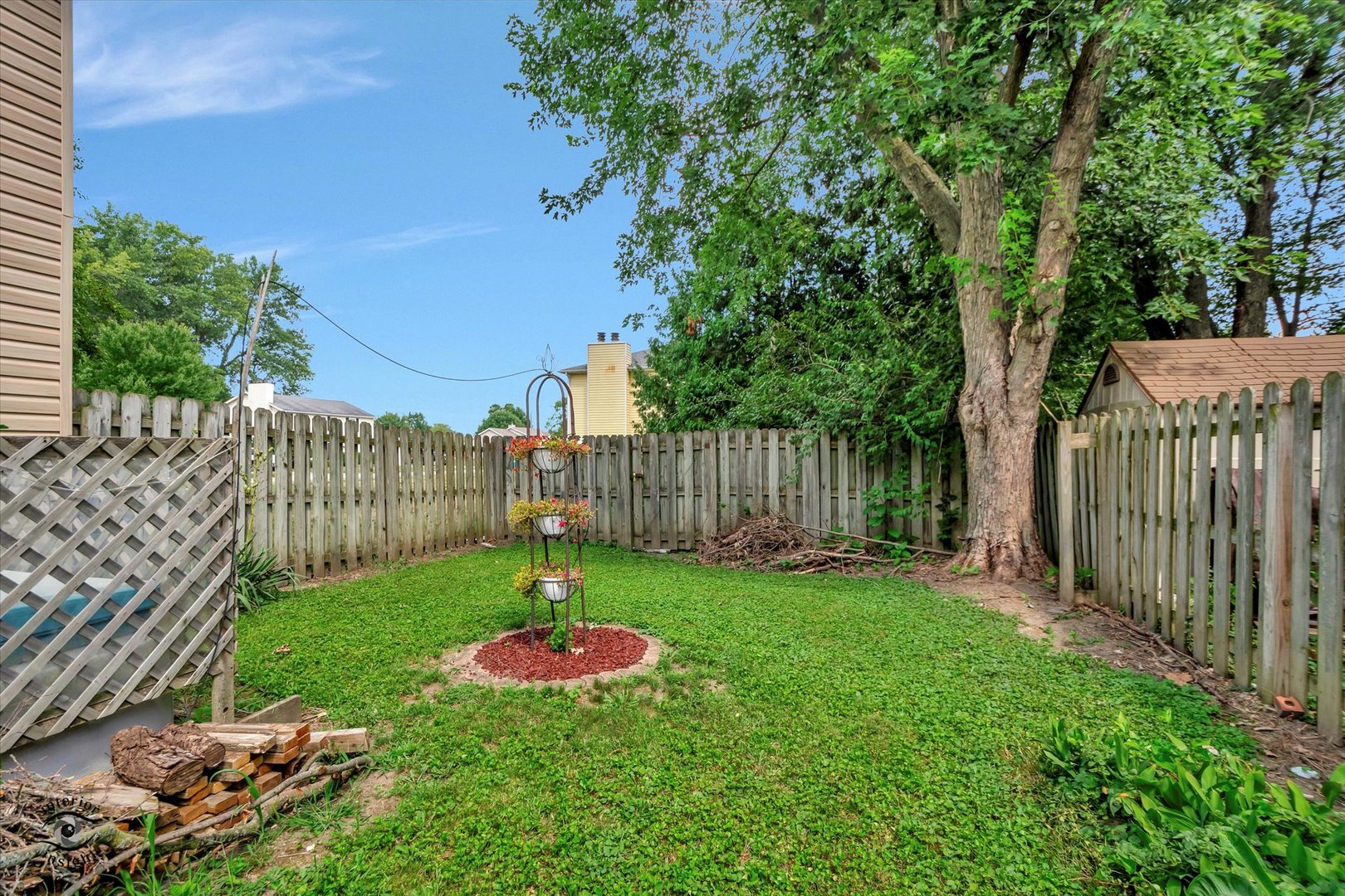 605 Ridge Street Wilmington, IL 60481 - Photo 4 of 26 a view of a backyard with table and chairs and wooden fence