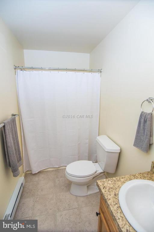 29890 Deal Island Road Princess Anne, MD 21853 - Photo 17 of 32 a bathroom with a granite countertop toilet and a sink