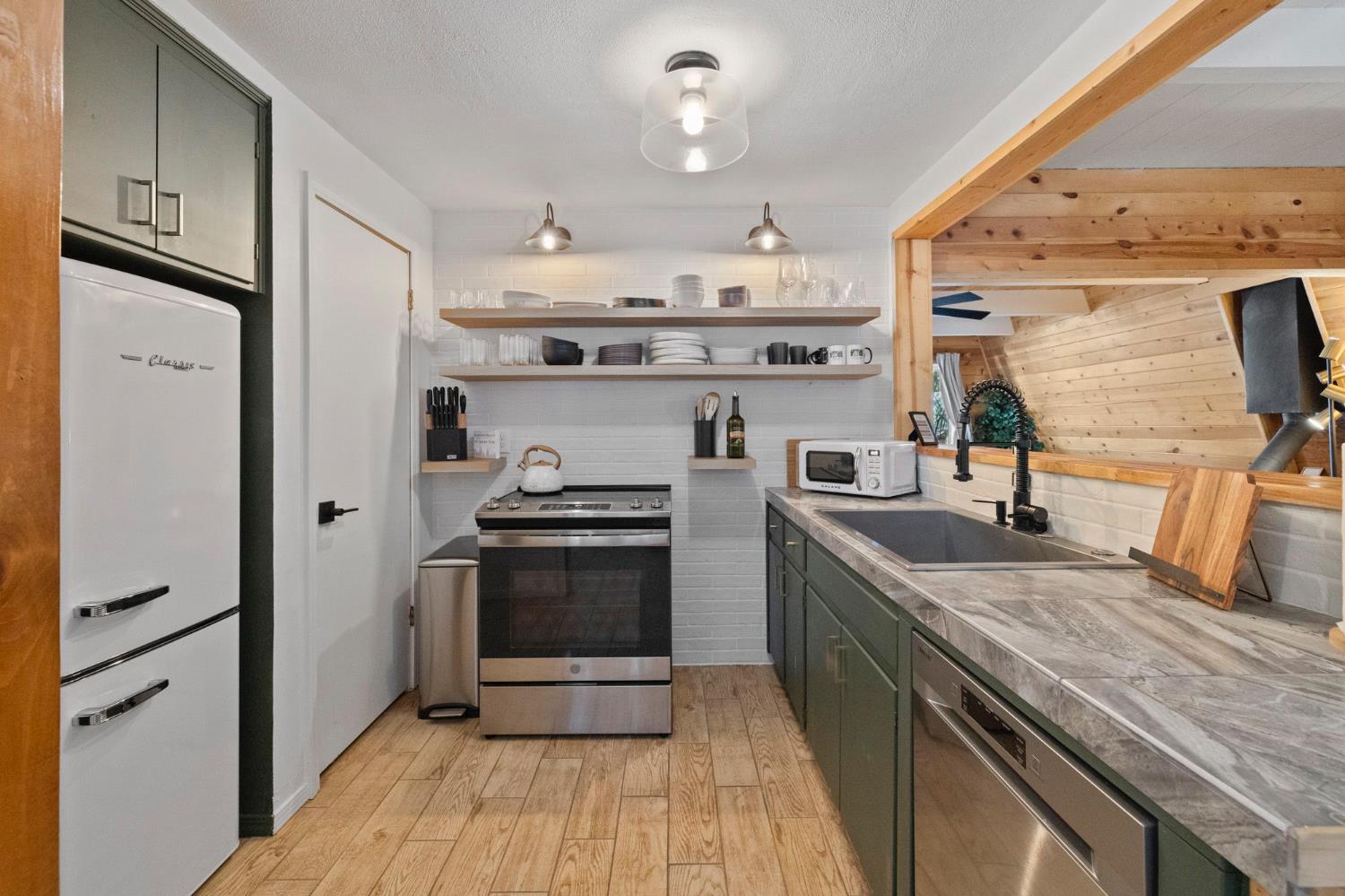 22785 West Ellmaro Road Long Barn, CA 95335 - Photo 10 of 28 a kitchen with stainless steel appliances granite countertop a stove and a refrigerator