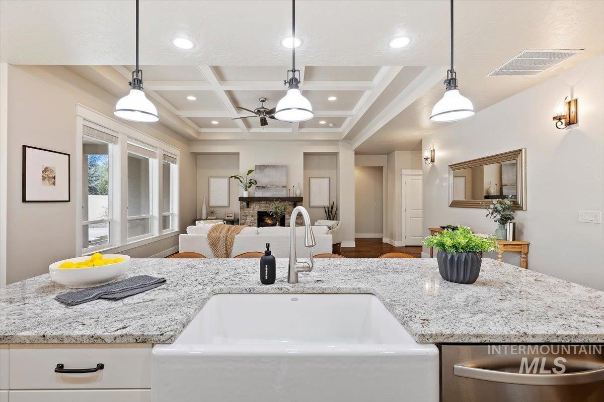 1366 North Waterbrook Way Star, ID 83669 - Photo 30 of 30 Kitchen with coffered ceiling, light stone counters, open floor plan, ceiling fan, and stainless steel dishwasher
